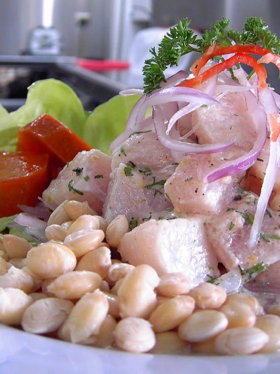 Ceviche de pescado con cebolla morada, maíz y lechuga