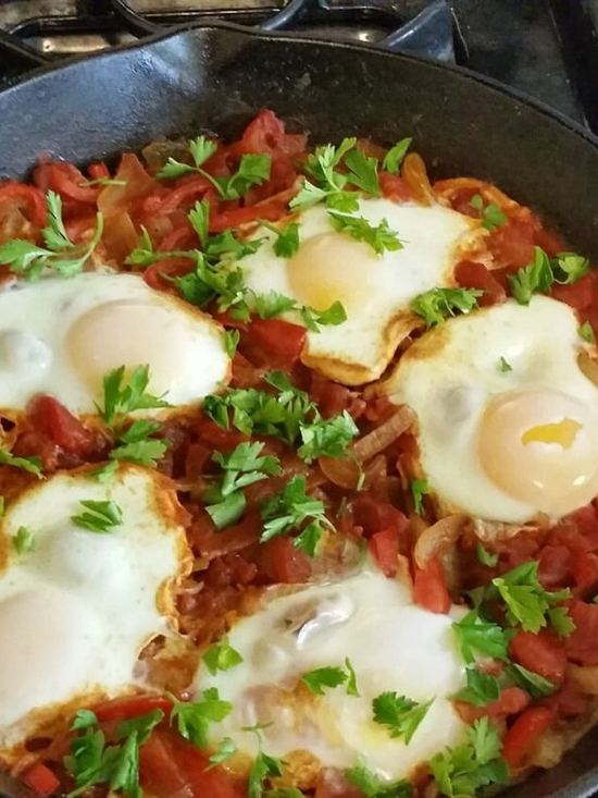 Shakshuka: huevos escalfados en salsa de tomate y pimiento en una sartén de hierro